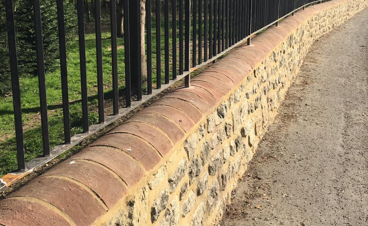 Re-pointing and repair to the ragstone base of an estate boundary wall